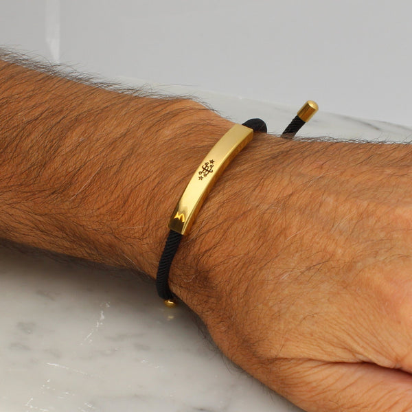 Adjustable gold bracelet with black nylon cord and engraved Ringstone Symbol by Maconi Jewelry
