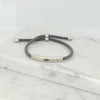Adjustable silver bracelet with grey nylon cord and engraved Ringstone Symbol by Maconi Jewelry