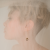 Woman wearing minimal gold chain earringswith engraved 9-pointed starpnedant by Maconi